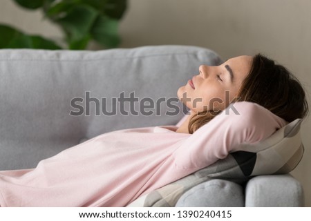 Side close up view young serene woman lying on comfy couch putting hands behind head closed her eyes sleeping or having day nap resting alone, lazy weekend at home refreshment and renew energy concept Royalty-Free Stock Photo #1390240415