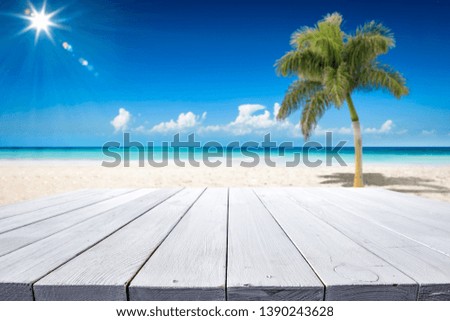 Table background of free space for your decoration and summer landscape of ocean with palm. Sunny day and blue sky. 