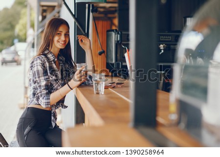 Beautiful girl sitting near bar. Lady in a shirt