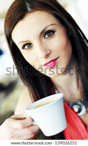 Young brunette girl enjoying a cup of coffee