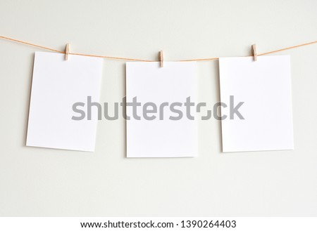 Three blank white papers hanging on the wall, mock up for artwork, photos, poster, prints.