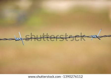 Wire fence close up with the countryside of background