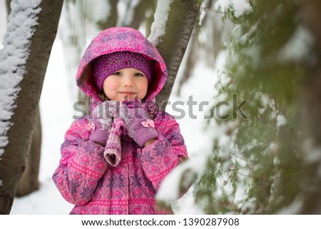 Little girl in the winter forest