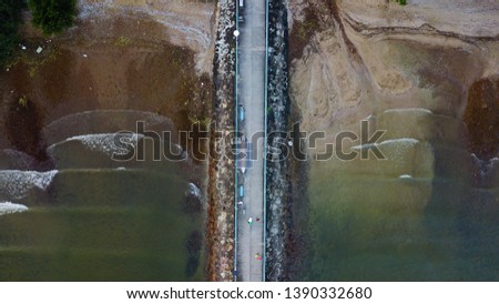 a beach and a bridge taken from a drone shot