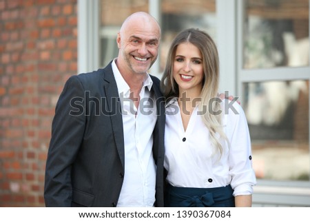 Elderly man and young woman smile