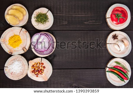 Set of seasonings and spices on a wooden brown background with tomato, onion. garlic, pepper