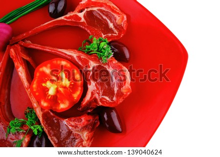 ribs served on red plate with tomatoes adn greenery