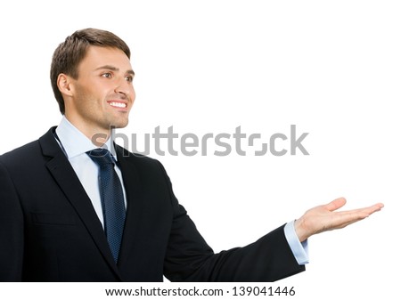 Happy smiling young business man showing blank area for sign or copyspase, isolated over white background