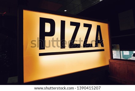 A trendy iconic cinematic typist font new york pizza sign inside a retro vintage hipster pizza diner in a city. Pop up eatery style pizza counter.                   