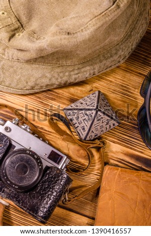Hipster hat, vintage camera, sunglasses, souvenir pyramid and passport on wooden background. Travel to Egypt. Top view