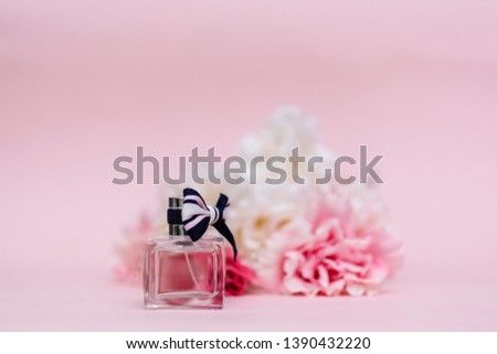 Bottle of perfume with flowers peonies on pink color background 