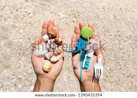 Concept of choice: save nature or continue to use disposable plastic. One hand holding beautiful shells, in the other - plastic waste. Beach sand on background. Environmental pollution problem. Royalty-Free Stock Photo #1390435394