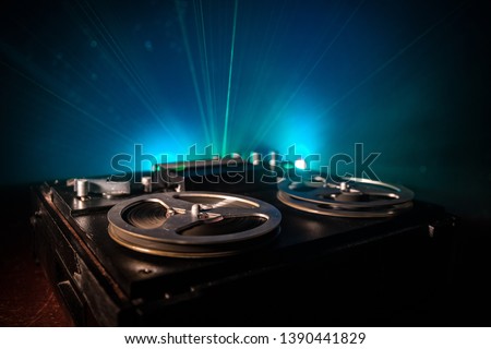 Old vintage reel to reel player and recorder on dark toned foggy background. Analog Stereo Open Reel Tape Deck Recorder Player with Reels. Selective focus