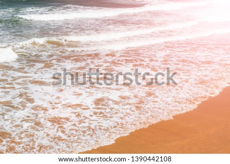 Stunning ocean sand beach with calm waves rolling ashore