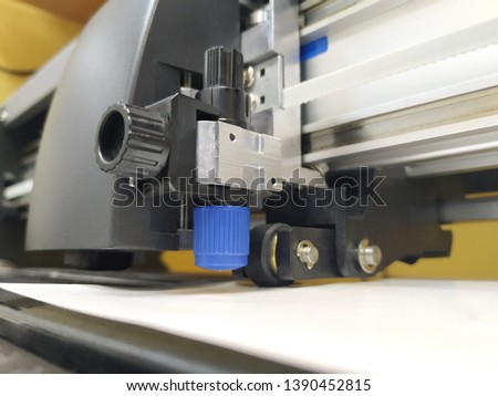 Cutting plotter close-up. The process of cutting a white film.