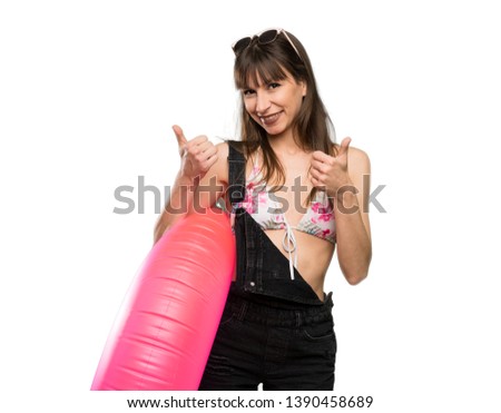 Young woman in bikini with thumbs up gesture and smiling over isolated white background