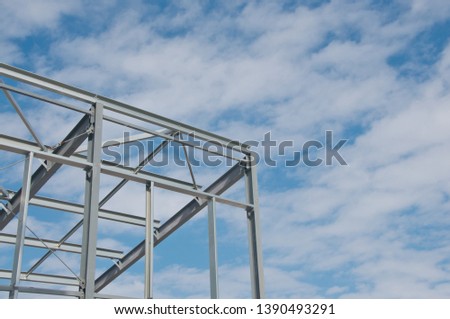 Metal frame of the new building against the blue sky with clouds