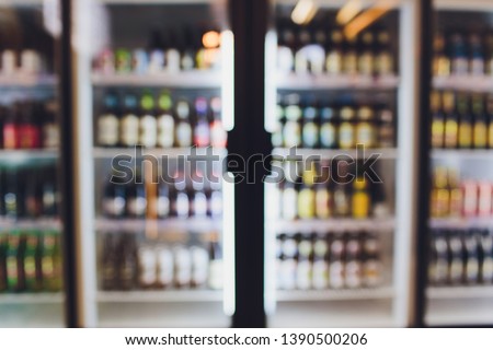 Background Blurred Defocused Beers are cooling in fridge, freezer or refrigerator shelf. Defocused Blurry Night life, Night Club, Bar, Pub, Store or Grocery Background concept image. Royalty-Free Stock Photo #1390500206