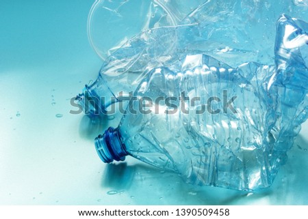 Used plastic bottles and cups against blue background. Ban single use plastic, zero waste concept. Copy space.