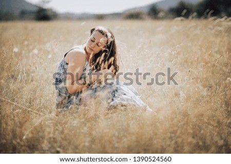 Beautiful young caucasian woman sitting on the summer grass meadow. Concept woman liberty
