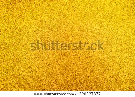 Closeup of gold glitter texture. Photo of yellow sparkle dust background.