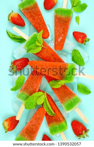 Watermelon flavored summer theme ice cream popsicles on pink and blue background.