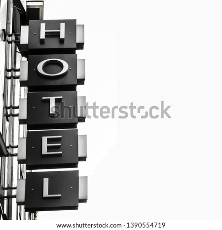 Neon Sign with the word Hotel under white sky
