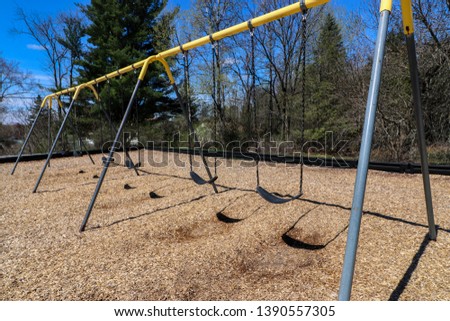 Empty Swing Set At School Playground Royalty-Free Stock Photo #1390557305