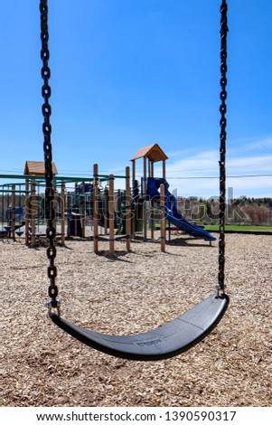 Empty Elementary School Playground & Swings Royalty-Free Stock Photo #1390590317