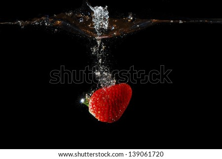 red juicy healthy strawberry makes bubbles in the water