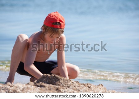 child on a beach being played sand