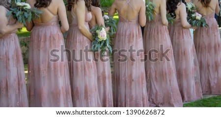 Row of bridesmaids with flower bouquets at wedding ceremony.
