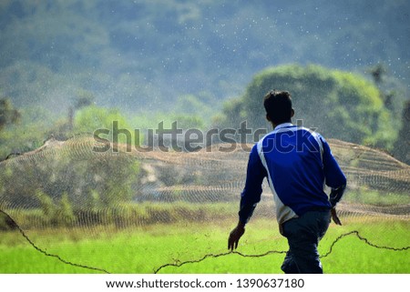 A man caught fish in the field Take pictures from the back