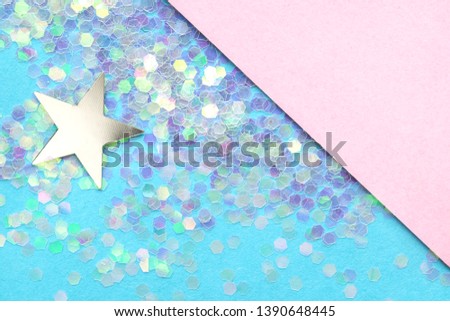 The background is divided into two parts, pink is empty on it a place for text, silver star and confetti is laid out on blue parts. Festive concept.