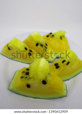 Piece of fresh Yellow watermelon doll hybrid unique tropical healthy fruit with bright flesh has small seeds and sweet test. Slices on plate isolated on white background. Use Wallpaper texture pattern