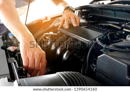 Car maintenance technician He is checking the auto engine, car inspection center. Royalty-Free Stock Photo #1390654160