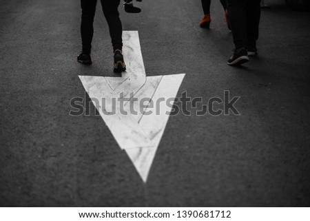 group of teenager walk against the arrow on street
