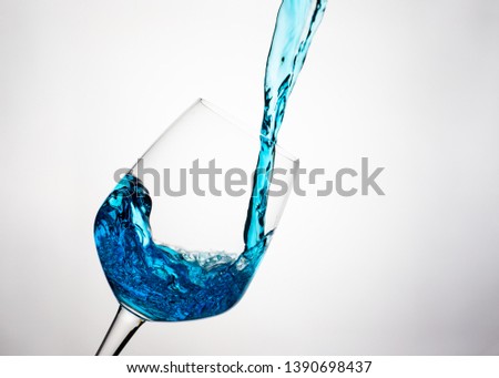 pouring blue colour drink or cocktail, lime into glass.