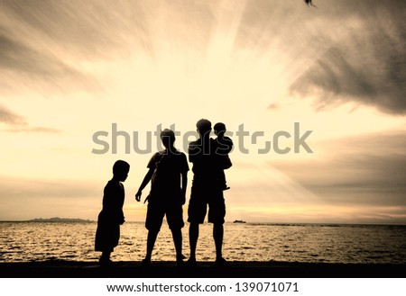 silhouette of happy family at the beach.