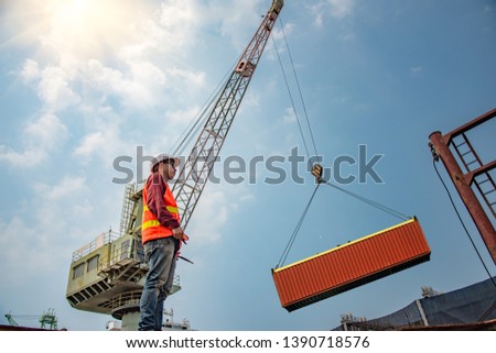 engineering, loading master takes control loading with gantry crane for lifting safety operation in loading the goods or shipment at job site, working with industrial and heavy lift