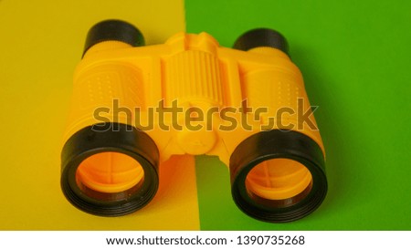 Binocular on green and yellow background