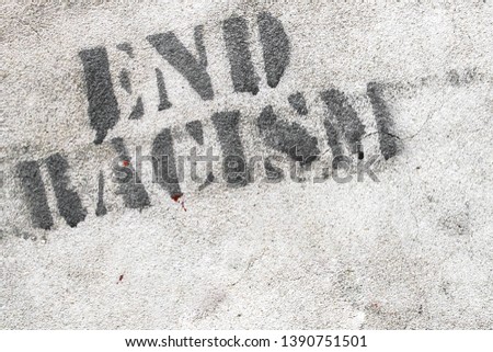 Graffiti on brick wall say - END RACISM. Ideal for concepts and backgrounds.