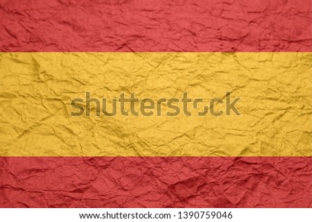 Spain flag on old crumpled craft paper. Textured background wallpaper for design.