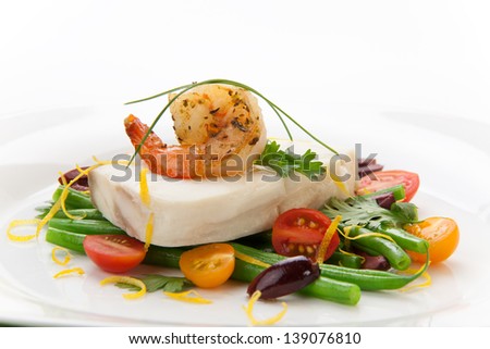Poached halibut with spicy shrimp, green beans, cherry tomatoes, black olives, and citrus sauce. 