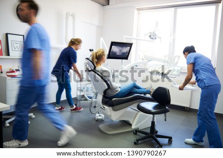 Blurred view of dentists and woman in dentist's Clinic Royalty-Free Stock Photo #1390790267