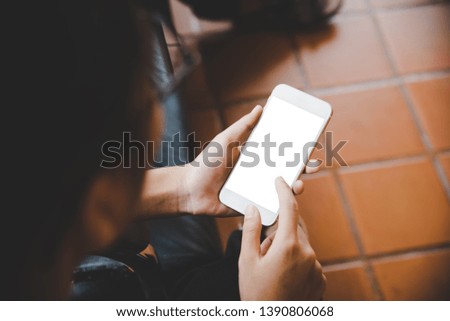 Mockup image of hand holding mobile phone blank white screen in office business concept