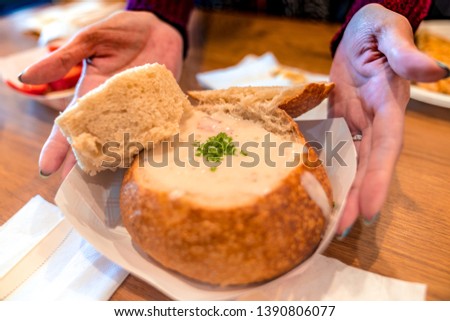 A picture of a lady holding a Clam Chowder Bread Bowl