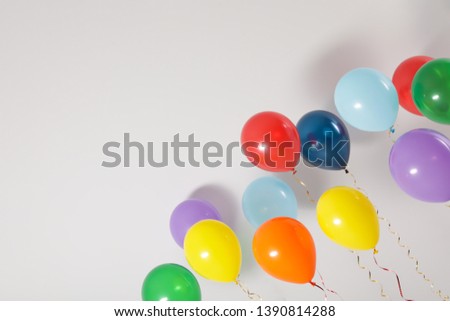 Different bright balloons on light background, space for text. Celebration time