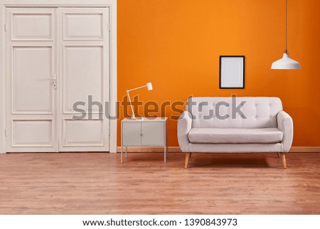Orange room wall background with sofa cabinet and lamp, white classic door interior.
