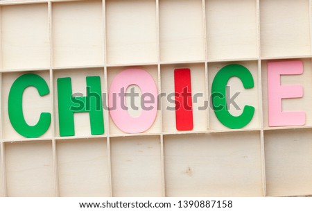 Word CHOICE made of colorful alphabet letters on wooden surface.